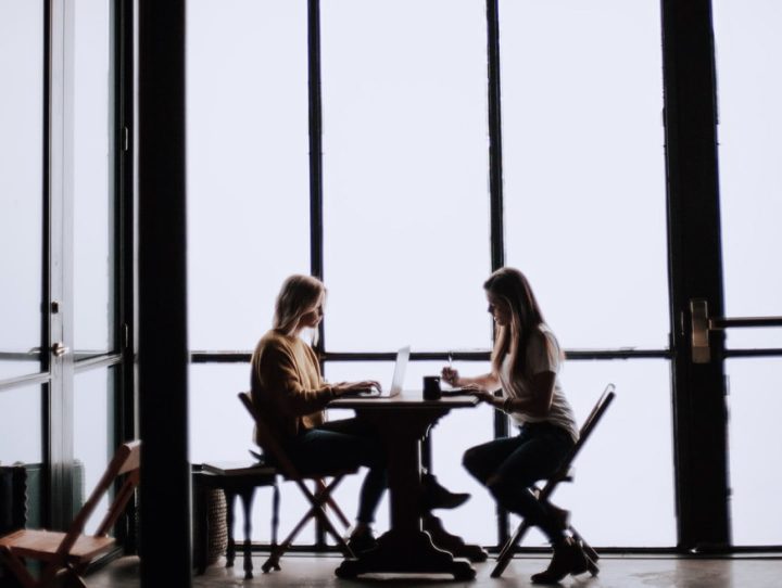 Två kvinnor som sitter och jobbar